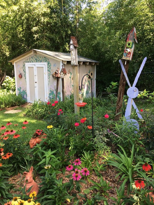 A hand-painted garden hut with flowers and garden art