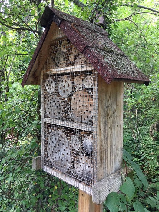 Roofed insect hotel on a wooden post
